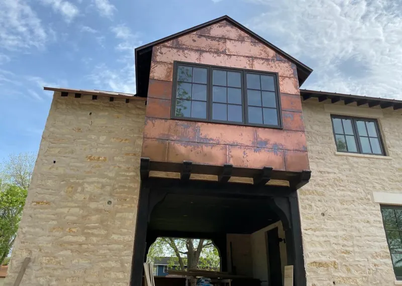 Copper metal panel facade on a stone building for Skylight Installation in Angleton